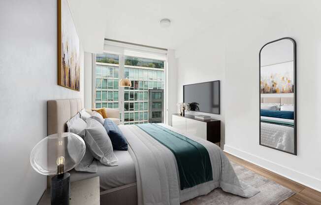 A modern bedroom with a large bed and a flat screen TV.