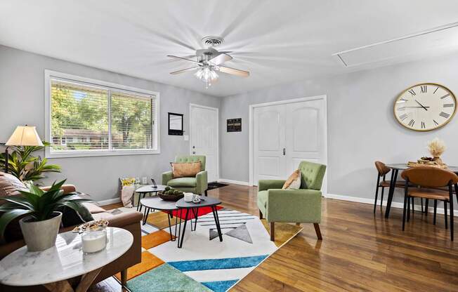 A living room with a ceiling fan and a clock on the wall.