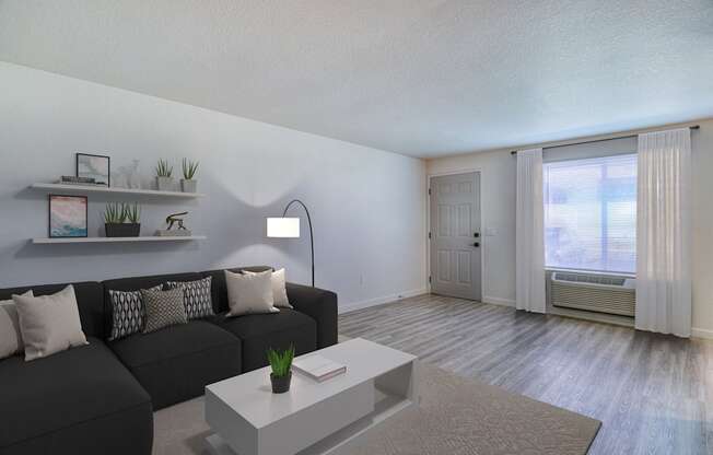 a living room with a black couch and a white coffee table