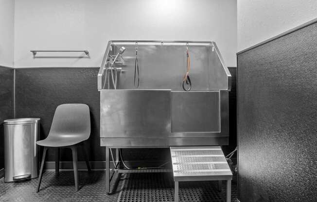 A clean, empty kitchen with a sink and a chair.