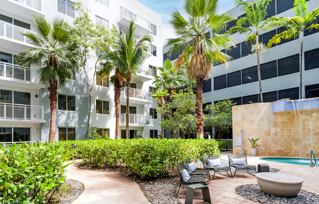A pool surrounded by palm trees and chairs.