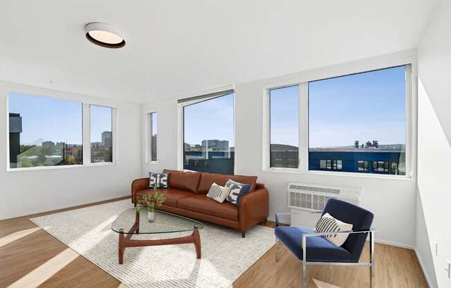 A living room with a brown couch, a blue chair, and a glass table.