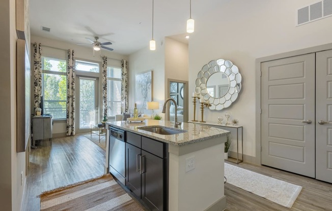 an open kitchen and living room with a sink and a ceiling fan