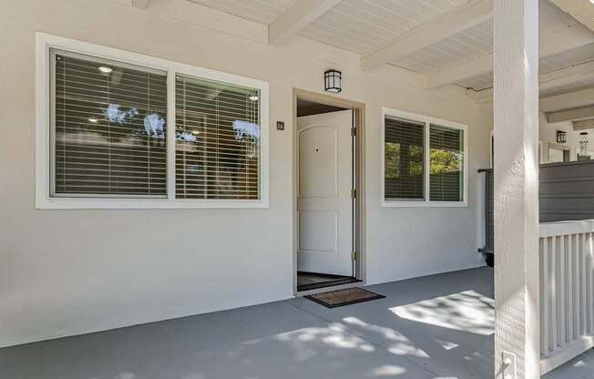 A white door is open to a patio.
