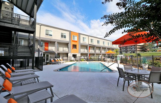 Poolside patio with lounge seating and covered tables.