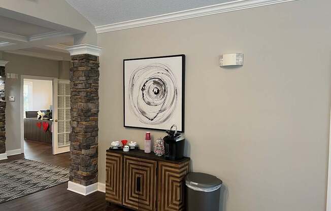 A hallway with a stone pillar and a framed picture on the wall.
