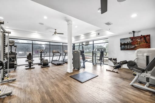 a gym with exercise machines and a large window