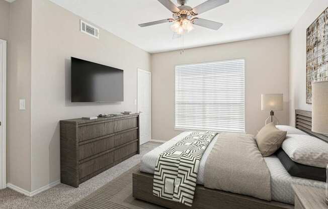 a bedroom with a large bed and a ceiling fan