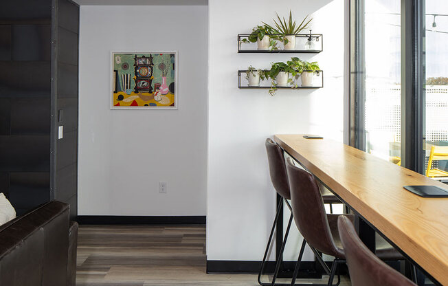 a long wooden table sitting next to a window at The Landing at 1001 NP, Fargo, North Dakota, 58102