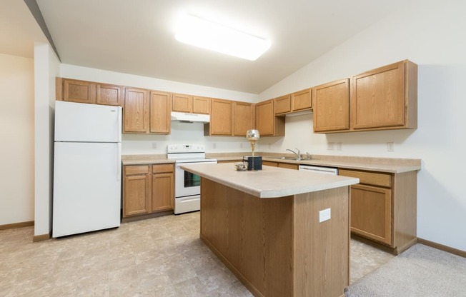 Large kitchen with white appliances and wooden cabinets at Sunset Ridge Apartments in Bismarck