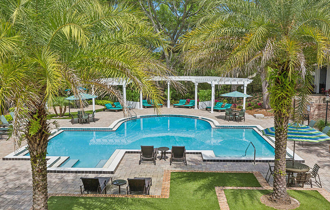 Aerial View of Community Swimming Pool with Pool Furniture at Grand Pavilion Apartments in Tampa, FL.