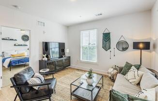 living room with a couch and a tv at The Merchant Apartments, Charleston, SC, 29403