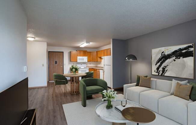 a living room and kitchen with a white couch and a table. Fargo, ND Prairie Park Apartments