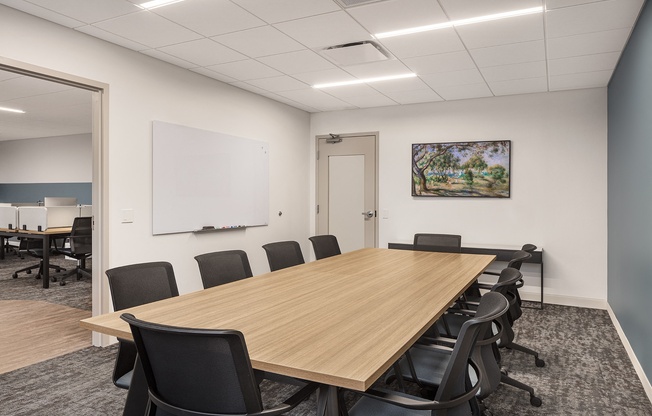 a conference room with a wooden table and black chairs