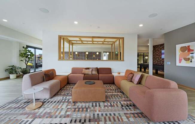 A living room with a large rug and a mirror on the wall.