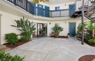 A courtyard with a bench and plants.