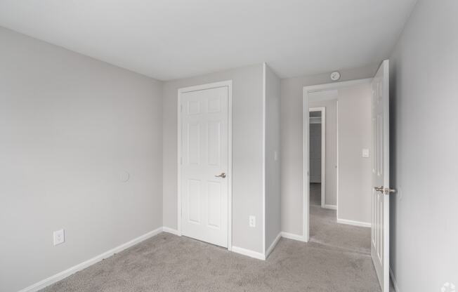 a bedroom with a white door and a closet