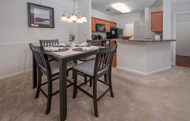 A dining room with a table set for four.