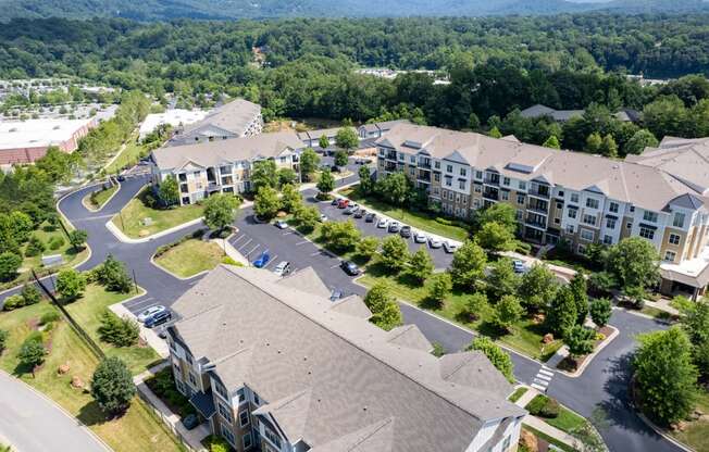 an aerial view of a large apartment complex with trees in the background