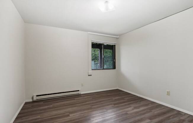 a living room with a window and a wooden floor