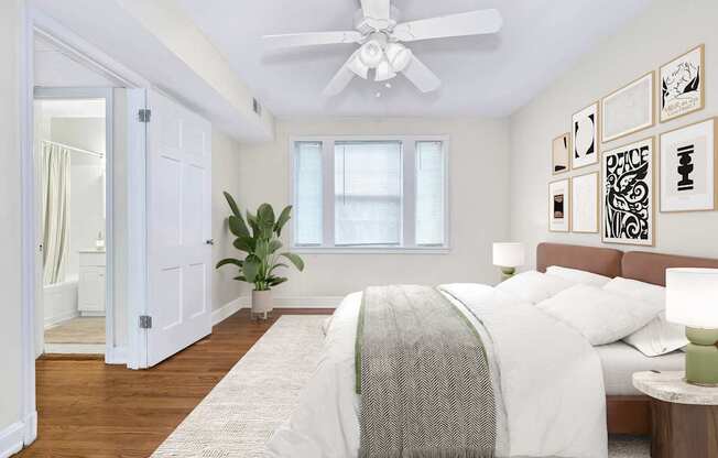 A bedroom with a bed, a ceiling fan, and a plant.