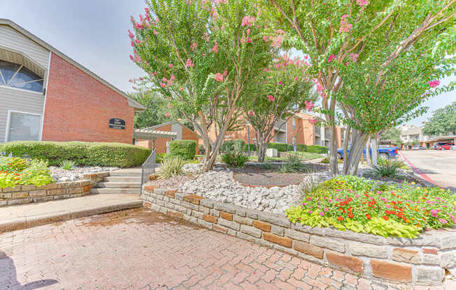 A brick wall with a flower bed in front of a building at Copper Hill Apartments, Bedford 76021