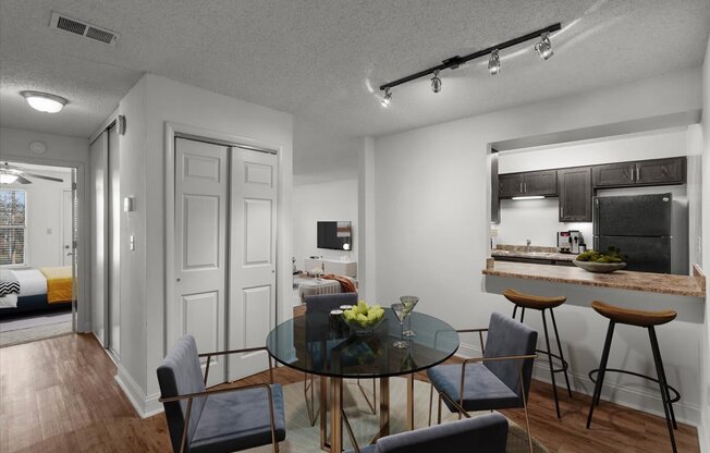 a dining room and kitchen with a glass table and chairs