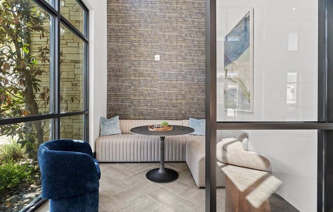 A living room with a blue chair and a round table.