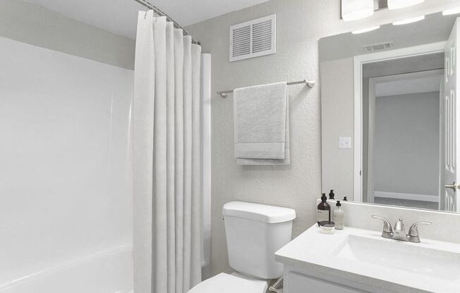a white bathroom with a shower and a toilet and a sink at Lakeside Villas, Orlando, FL