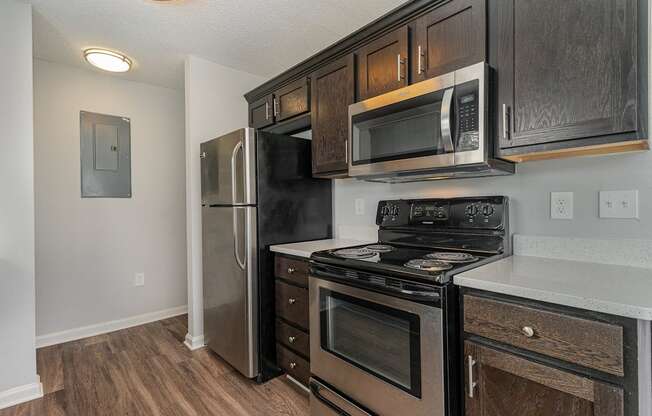 a kitchen with black appliances and wooden cabinets and a stainless steel refrigerator
