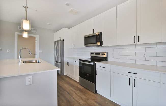 a kitchen with white cabinets and a sink and a refrigerator