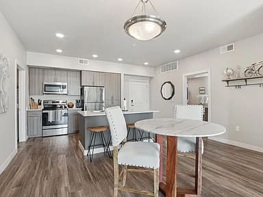 A modern kitchen with a dining table and chairs.