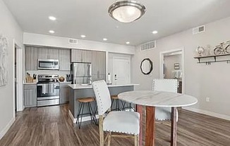 A modern kitchen with a dining table and chairs.