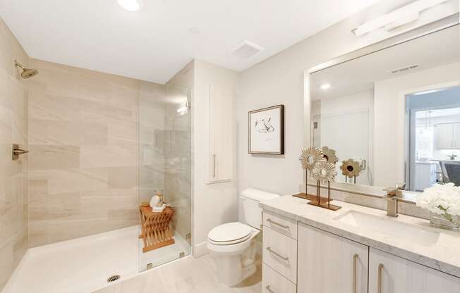 a white bathroom with a shower and a sink and a toilet
