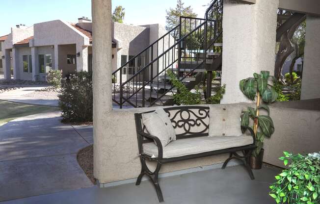 a bench sitting on a porch in front of a building