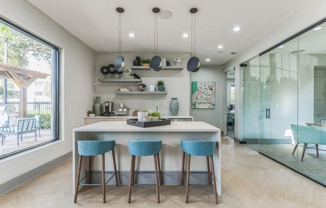 Kitchen with an island and three blue stools at The Atlantic Preserve, Plantation, FL