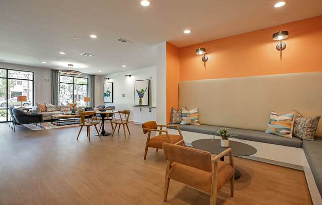 A living room with a grey couch and wooden chairs.