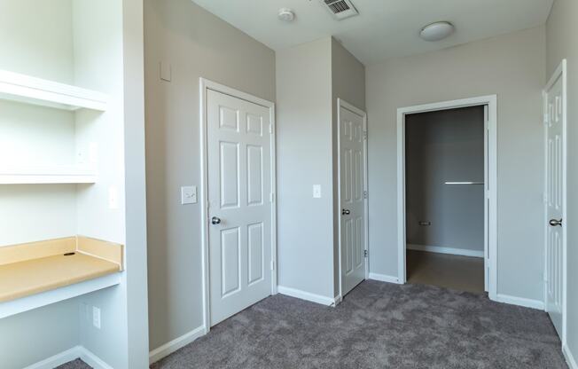 a bedroom with a closet and a door to a hallway