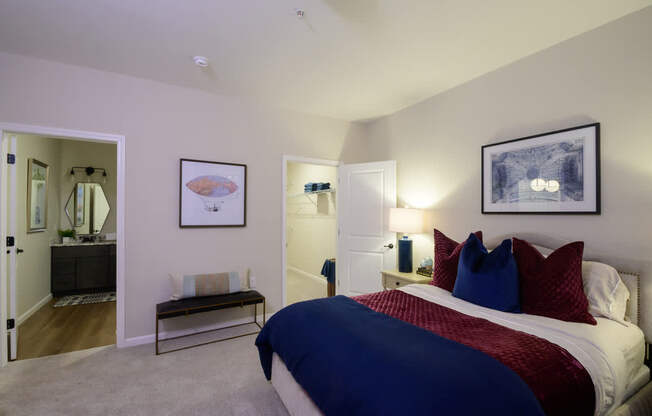 A bedroom with a bed, nightstands, and a painting on the wall.