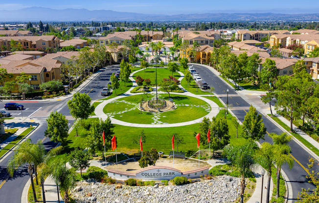 A view of a park in a residential area with a sign that says College Park.