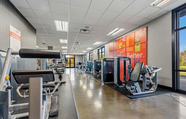 A gym with a variety of equipment including treadmills, weights, and exercise machines.