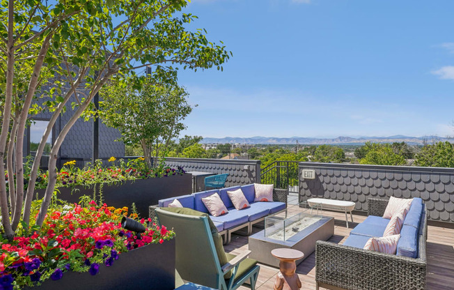 a roof deck with couches and chairs and a view of the city