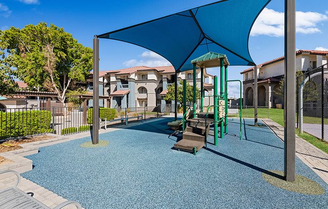 Community Playground with Blue Canopy at Stillwater Apartments in Glendale, AZ.