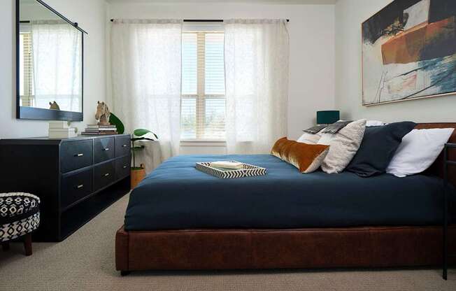 a bedroom with a large bed and a dresser