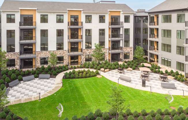 an aerial view of an apartment building with a lawn and garden