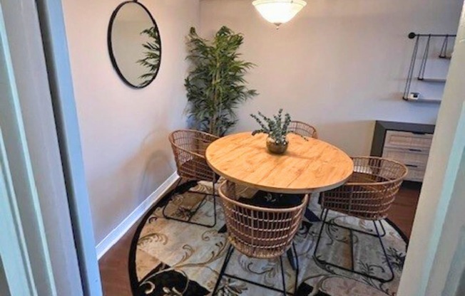 A dining room with a round table and chairs.