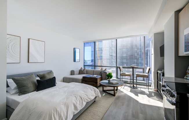 a bedroom with a bed and a couch and a large window