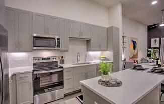 A modern kitchen with a stainless steel refrigerator and oven.