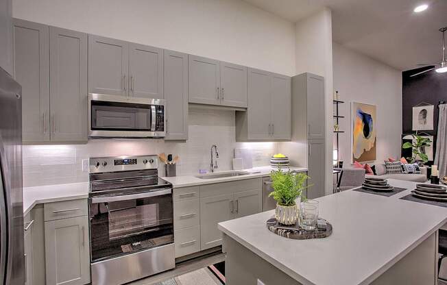 A modern kitchen with a stainless steel refrigerator and oven.
