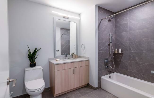 a bathroom with a toilet sink and shower and a mirror